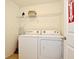 Functional laundry room with appliances, storage shelving, and convenient access for household chores at 2660 Santosh Cv, Kissimmee, FL 34746