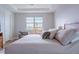 Serene bedroom with plush bedding, a sitting area by the window, and a peaceful view of the outdoors at 2841 Willowseed Ln, St Cloud, FL 34772