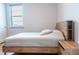 Cozy bedroom with a wood frame platform bed, matching nightstand and lots of natural light from the window at 2841 Willowseed Ln, St Cloud, FL 34772