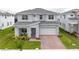 Charming two-story home featuring a covered front porch, an attached two-car garage and a lush green lawn at 2841 Willowseed Ln, St Cloud, FL 34772