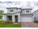 Beautiful two-story home featuring a covered front porch, a well-manicured lawn, and an attached two-car garage at 2841 Willowseed Ln, St Cloud, FL 34772