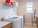 Efficient laundry room featuring modern washer and dryer, storage shelves, and convenient drying rack at 2841 Willowseed Ln, St Cloud, FL 34772