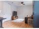 Modern living room featuring sleek wood laminate floors, a comfortable leather sofa and television at 2841 Willowseed Ln, St Cloud, FL 34772