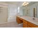 Bright bathroom featuring dual sinks, natural wood cabinets, a glass enclosed shower and a tub at 2903 Joseph Cir, Oviedo, FL 32765