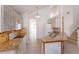 Bright kitchen with white appliances, tile floors, granite countertops, and natural wood cabinets at 2903 Joseph Cir, Oviedo, FL 32765