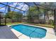 A sunny pool area with lush greenery and a screened enclosure, perfect for relaxation and entertaining at 2903 Joseph Cir, Oviedo, FL 32765