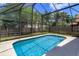 Swimming pool in screened enclosure with blue skies and lush landscaping at 2903 Joseph Cir, Oviedo, FL 32765