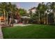 Expansive backyard with artificial turf, playground set, patio and mature landscaping and shady mature trees at 2918 Wessex St, Orlando, FL 32803