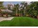 Lush backyard featuring manicured lawn and tropical landscaping, and a patio with table and chairs at 2918 Wessex St, Orlando, FL 32803