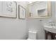 Simple powder room featuring botanical prints, a large gold-trimmed mirror, and a wall mounted sink at 2918 Wessex St, Orlando, FL 32803