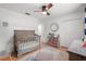 Well-lit Bedroom with a wooden crib, patterned rug, and organized bookshelf at 2918 Wessex St, Orlando, FL 32803