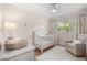 Comfortable Bedroom offers soft pink walls, a white crib, a side table with lamp, and a cozy rocking chair at 2918 Wessex St, Orlando, FL 32803