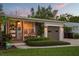 Charming single-story home featuring wood porch columns, beautiful landscaping and a brown garage door at 2918 Wessex St, Orlando, FL 32803