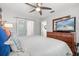 Comfortable bedroom featuring a ceiling fan, dresser with TV, and sliding closet door at 2918 Wessex St, Orlando, FL 32803