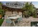 Covered outdoor kitchen with stainless steel grill, bar area, and table with seating by the pool at 2918 Wessex St, Orlando, FL 32803