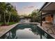 Relaxing backyard pool featuring a covered patio, an outdoor kitchen, and lush tropical landscaping at 2918 Wessex St, Orlando, FL 32803