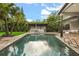Relaxing swimming pool with surrounding patio, outdoor kitchen, lush landscaping, and comfortable seating areas at 2918 Wessex St, Orlando, FL 32803
