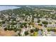 Expansive aerial view of a residential community with lush greenery, streets, and a large lake in the background at 294 Hunt St, Clermont, FL 34711