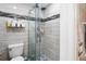 Bathroom featuring tiled walls, a glass-enclosed shower, and a low-flow toilet at 294 Hunt St, Clermont, FL 34711