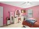 Bedroom featuring pink walls, wood-look flooring, and an ornate vanity with a large mirror at 294 Hunt St, Clermont, FL 34711