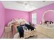 Bedroom featuring pink walls, wood-look flooring, and a white ornate bed and vanity at 294 Hunt St, Clermont, FL 34711