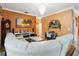 Inviting living room with orange walls, fireplace, hardwood floors, and comfortable white leather sectional sofa at 294 Hunt St, Clermont, FL 34711
