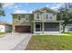 Two-story home with a well-maintained lawn, screened front porch, and a two car garage at 3842 Klondike Pl, Sanford, FL 32771