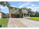 Two-story home with a well-maintained lawn, screened front porch, and a two car garage at 3842 Klondike Pl, Sanford, FL 32771