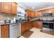 Well-lit kitchen with wooden cabinets, stainless steel appliances and mosaic backsplash at 3842 Klondike Pl, Sanford, FL 32771