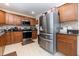 Bright kitchen featuring granite counters, stainless steel fridge, and warm-toned cabinets at 3842 Klondike Pl, Sanford, FL 32771