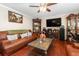 Comfortable living room with a leather sofa, a fireplace, and wood flooring at 3842 Klondike Pl, Sanford, FL 32771
