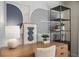 A modern desk setup with decorative lamps, artwork, open shelves, and a comfortable chair at 393 Meadowland Pt, Oviedo, FL 32765