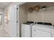 A laundry room features a new white washer and dryer with a shelf above them at 393 Meadowland Pt, Oviedo, FL 32765