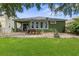 Large backyard with stone patio, green grass, overhead tree coverage and view of back of home at 4813 River Gem Ave, Windermere, FL 34786