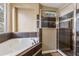 Bathroom with a large tub, a glass walk-in shower, and a tiled wall at 4813 River Gem Ave, Windermere, FL 34786