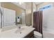 Bathroom featuring a large mirror, neutral tile, and a shower-tub combination at 4813 River Gem Ave, Windermere, FL 34786