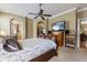 Comfortable bedroom with ceiling fan, TV, walk-in closet, and bathroom entrance at 4813 River Gem Ave, Windermere, FL 34786