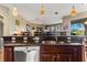 Features an open kitchen layout with dark cabinetry, granite countertops, stainless steel appliances and pendant lighting at 4813 River Gem Ave, Windermere, FL 34786