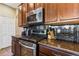 Well equipped kitchen with stainless steel oven, range, microwave, dark cabinets, granite countertops and wine rack at 4813 River Gem Ave, Windermere, FL 34786