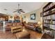 Open concept living room with laminated floors, book shelf, and leather sofas at 4813 River Gem Ave, Windermere, FL 34786
