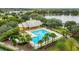 Aerial view of community pool and recreation center with palm trees, lounge chairs, and surrounding nature at 4813 River Gem Ave, Windermere, FL 34786