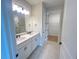 Bathroom featuring double sinks with modern fixtures, a tile floor, and a walk-in closet at 5158 Gardenrow Dr, St Cloud, FL 34772