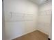 Walk-in closet with wire shelving and wood-look flooring offers ample storage at 5158 Gardenrow Dr, St Cloud, FL 34772
