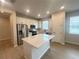 Modern kitchen featuring white cabinets, stainless steel appliances, a kitchen island, and wood flooring at 5158 Gardenrow Dr, St Cloud, FL 34772
