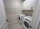 Laundry room featuring washer, dryer, and storage cabinets at 5158 Gardenrow Dr, St Cloud, FL 34772