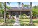 Charming home featuring a cozy screened front porch, stone chimney, and mature trees at 549 Wellon Ave, Orlando, FL 32833