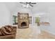 Spacious living room with tile floors, ceiling fan, stone fireplace, and access to the dining area at 549 Wellon Ave, Orlando, FL 32833