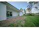 Exterior back yard view with covered patio, manicured lawn, landscaping, and lush greenery at 6054 Sw 154Th Place Rd, Ocala, FL 34473
