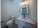 A half bathroom featuring a modern vanity with a white countertop and black hardware accents at 6054 Sw 154Th Place Rd, Ocala, FL 34473