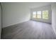 Bright, empty bedroom with a series of windows and new gray flooring, ready for personalization at 6054 Sw 154Th Place Rd, Ocala, FL 34473